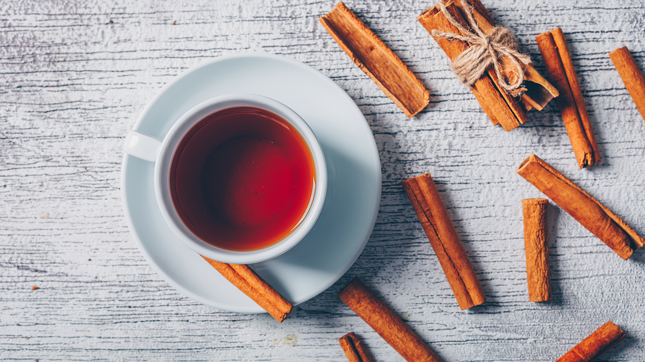 Top view of a cup of tea with dry cinnamon