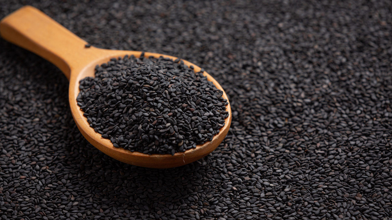 A background with a spoonful of black seeds