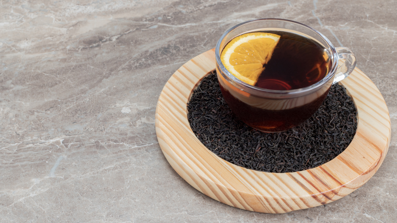 Black tea with a slice of lemon on a wooden plate
