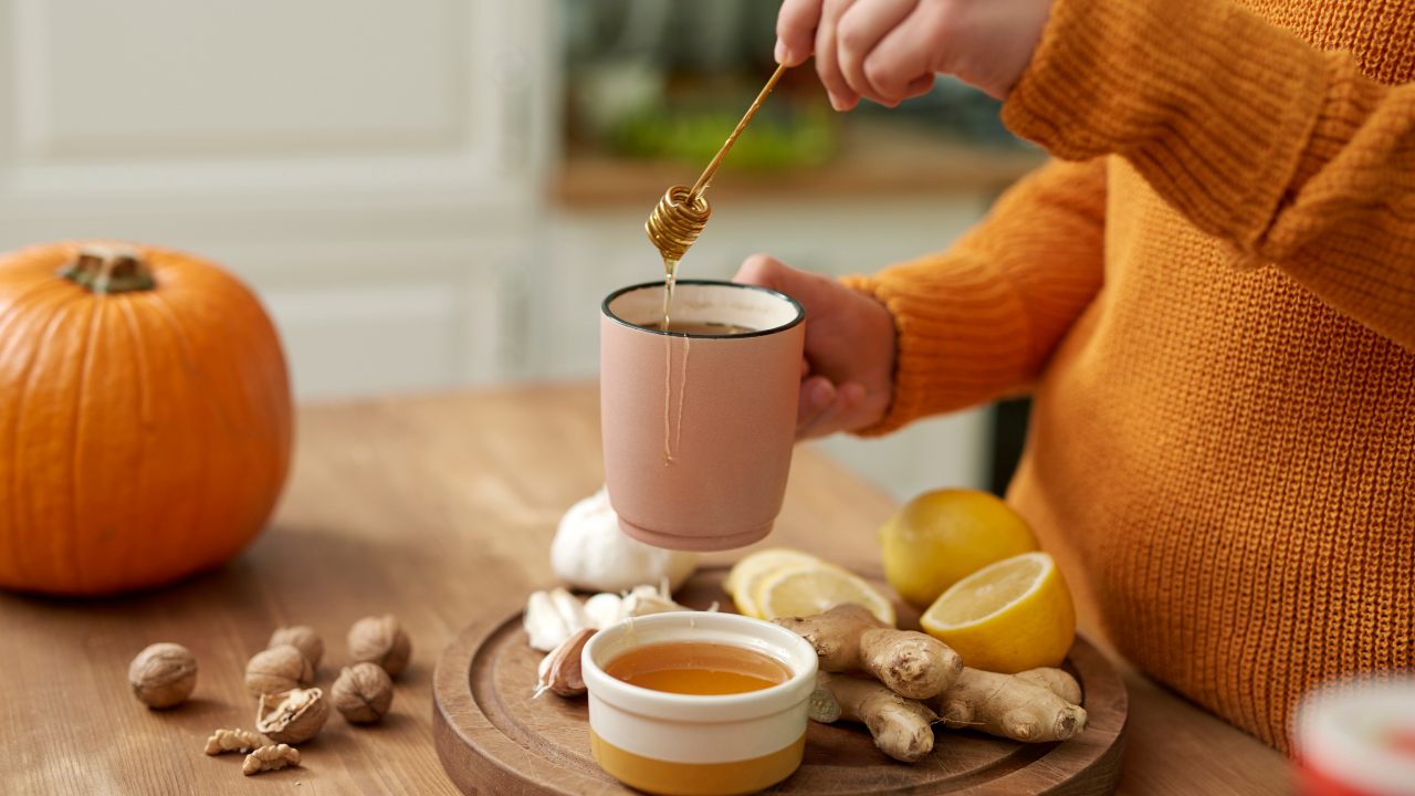 A woman making ginger tea with honey
