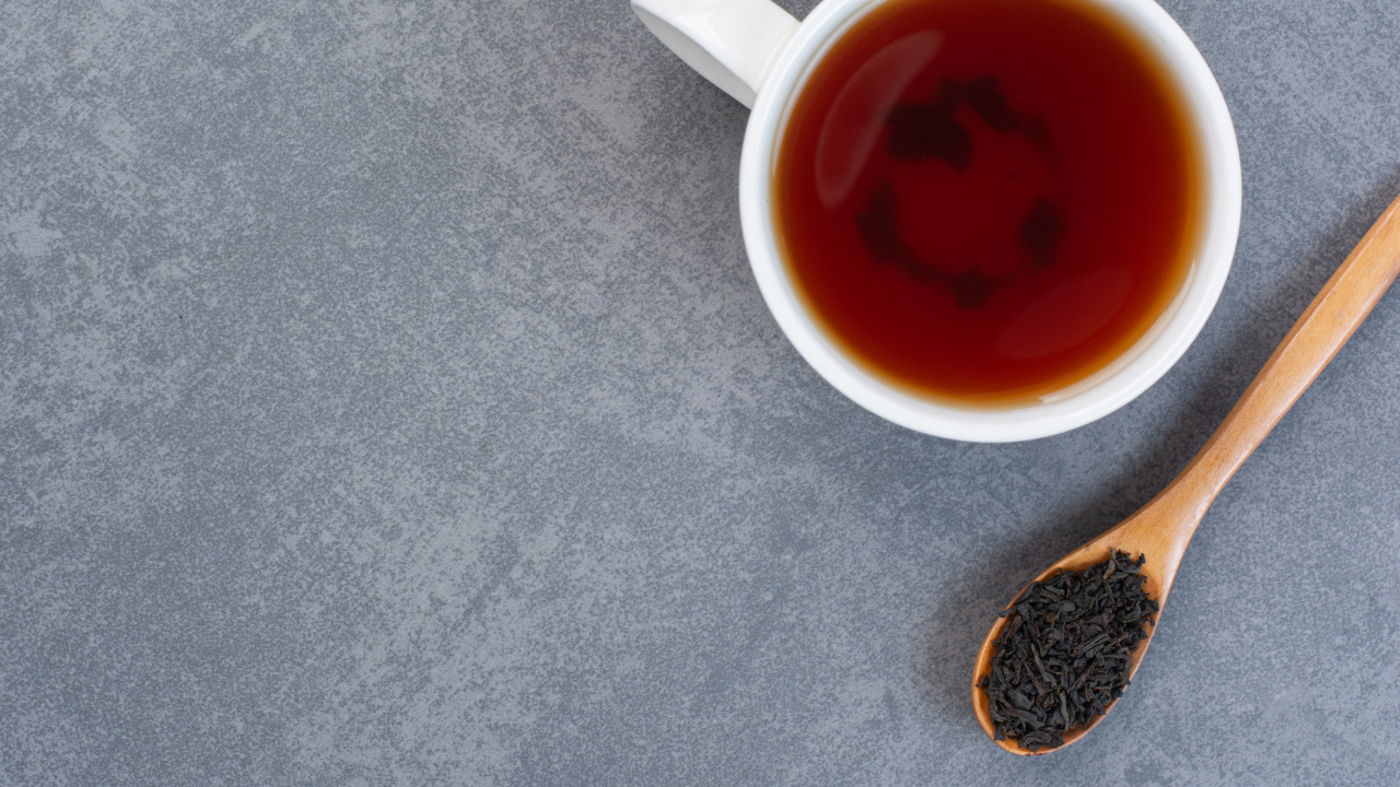 A cup of tea with a wooden spoon full of seeds