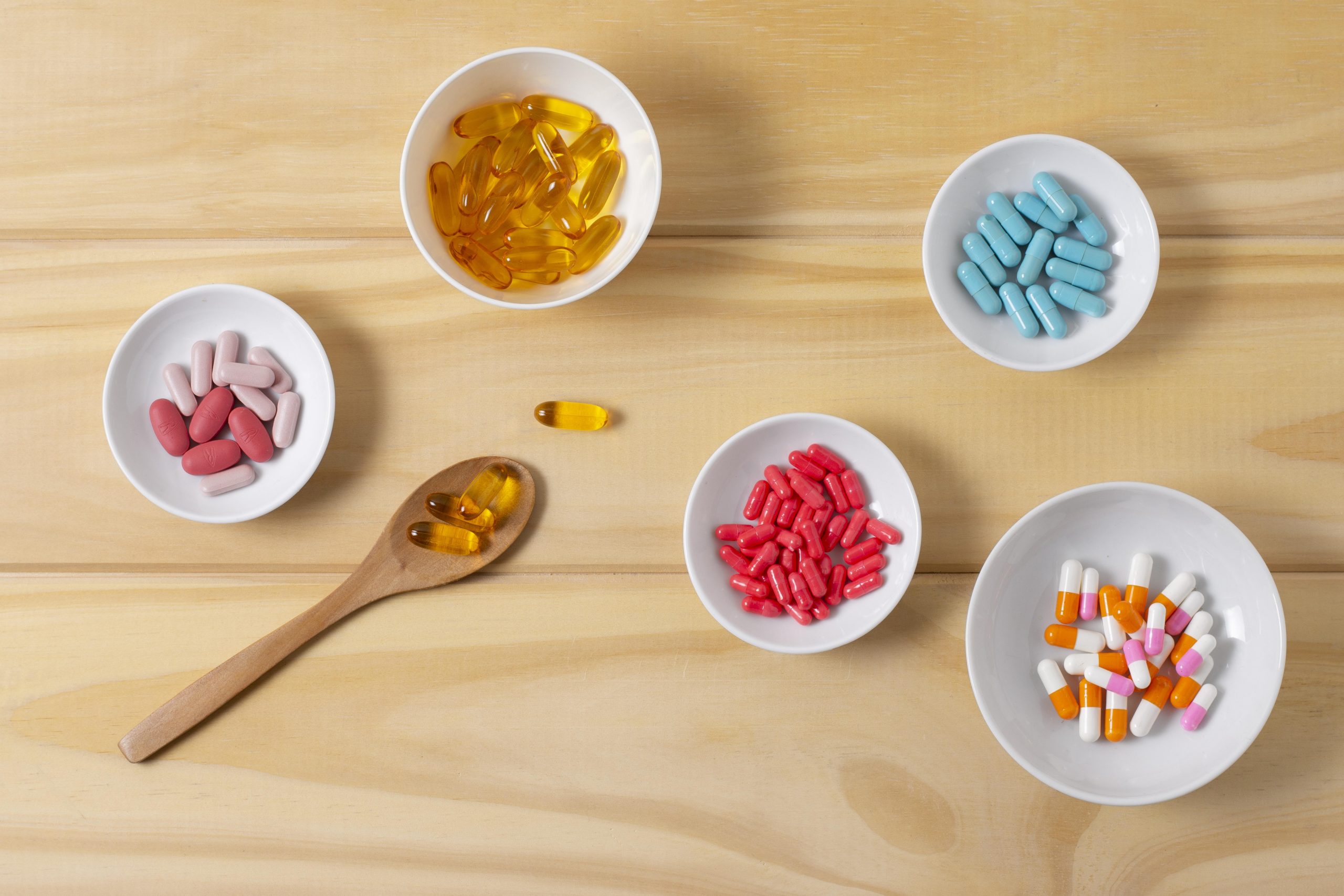 Top view of bowls filled with different vitamins