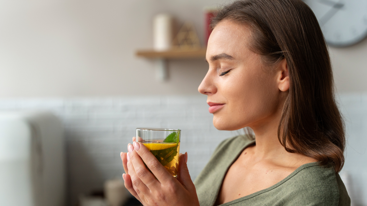 A woman is relaxing while drinking chamomile tea at home 